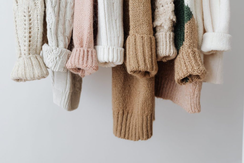 colorful sweaters hanging from a rack