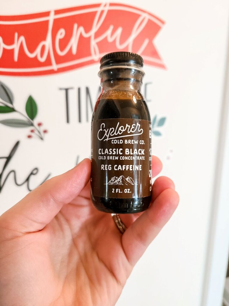 A single bottle of Explore Cold Brew held by a woman's hand.