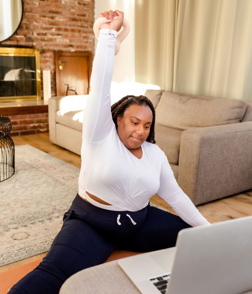 Woman holding a weight fits daily movement into her day more by working out one body part at a time.