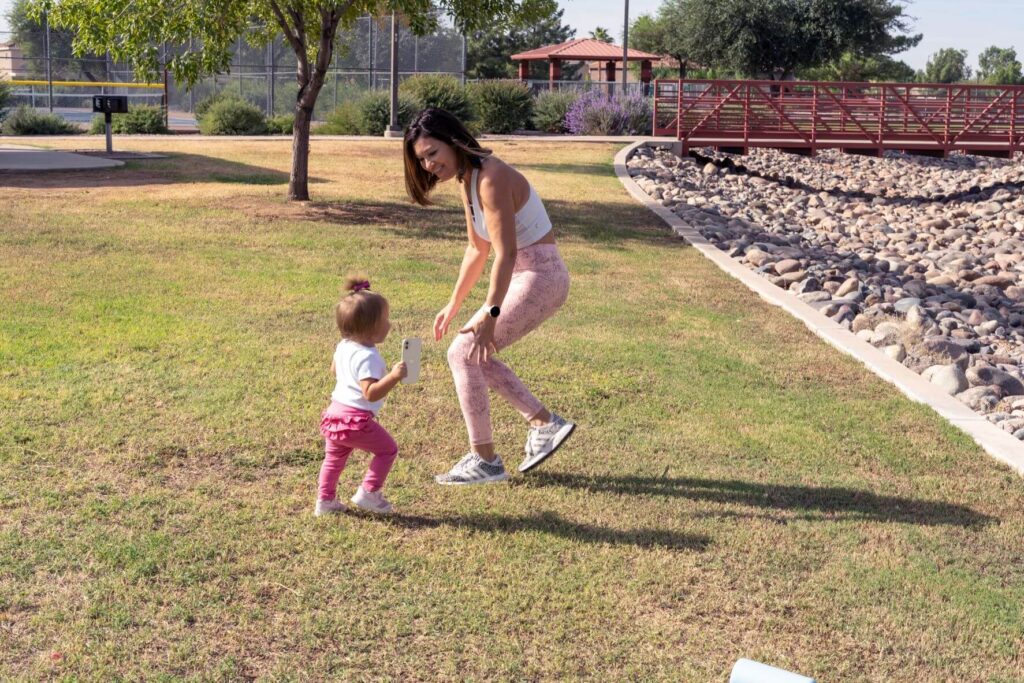 Mom playing on the grass with her daughter; a great and easy way to fit movement into your day as a busy mom.