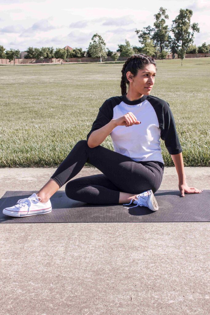 Outdoor yoga like this woman on a yoga mat is doing is the perfect activity for spring self-care.