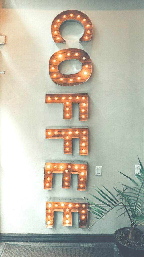 A collection of letters hanging on the wall in a vertical application that spell the word coffee.