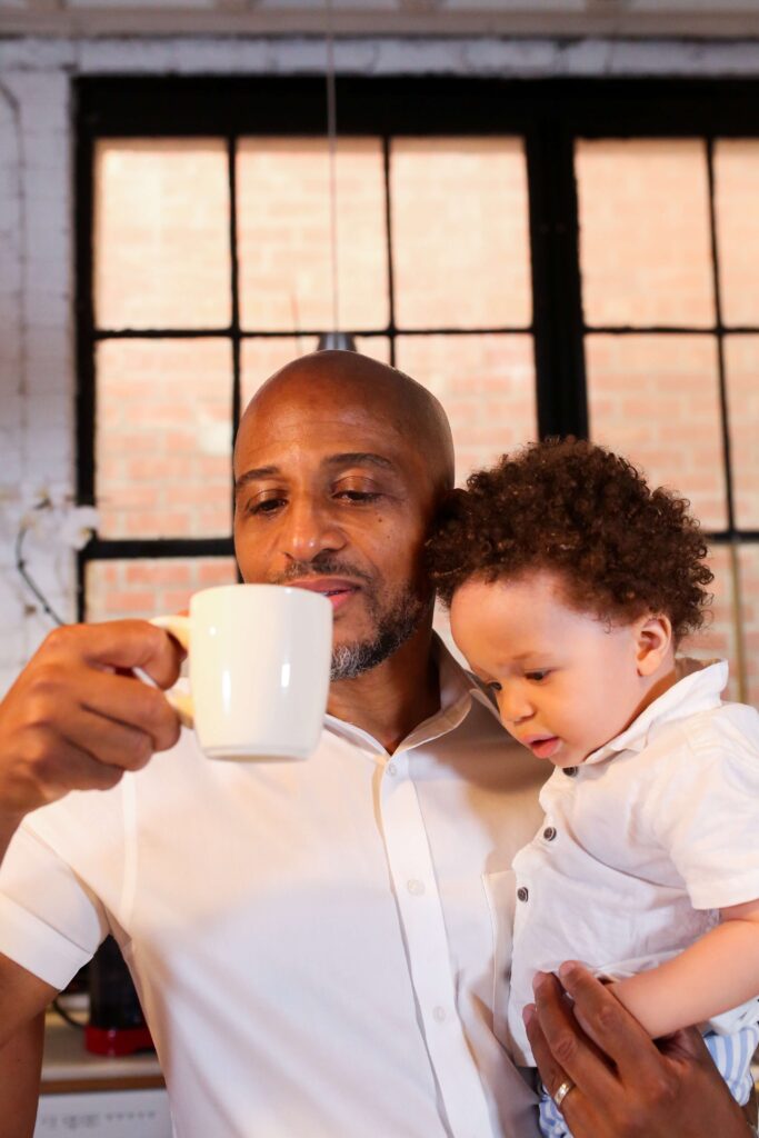 A dad's coffee is so important to him. Look at this dad holding his child and a cup of coffee at the same time.