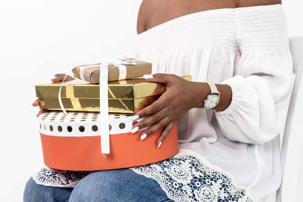 A woman holding gift boxes on her lap.