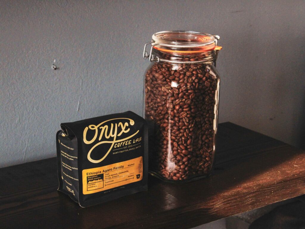 A bag of Onyx Coffee Lab coffee from the Onyx collection next to a jar filled with coffee beans.