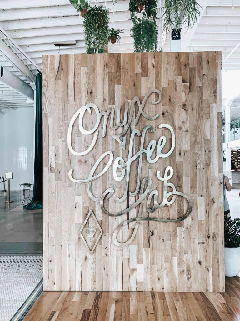 A silver letter sign on a light wood background for Onyx Coffee Lab at one of their physical locations.