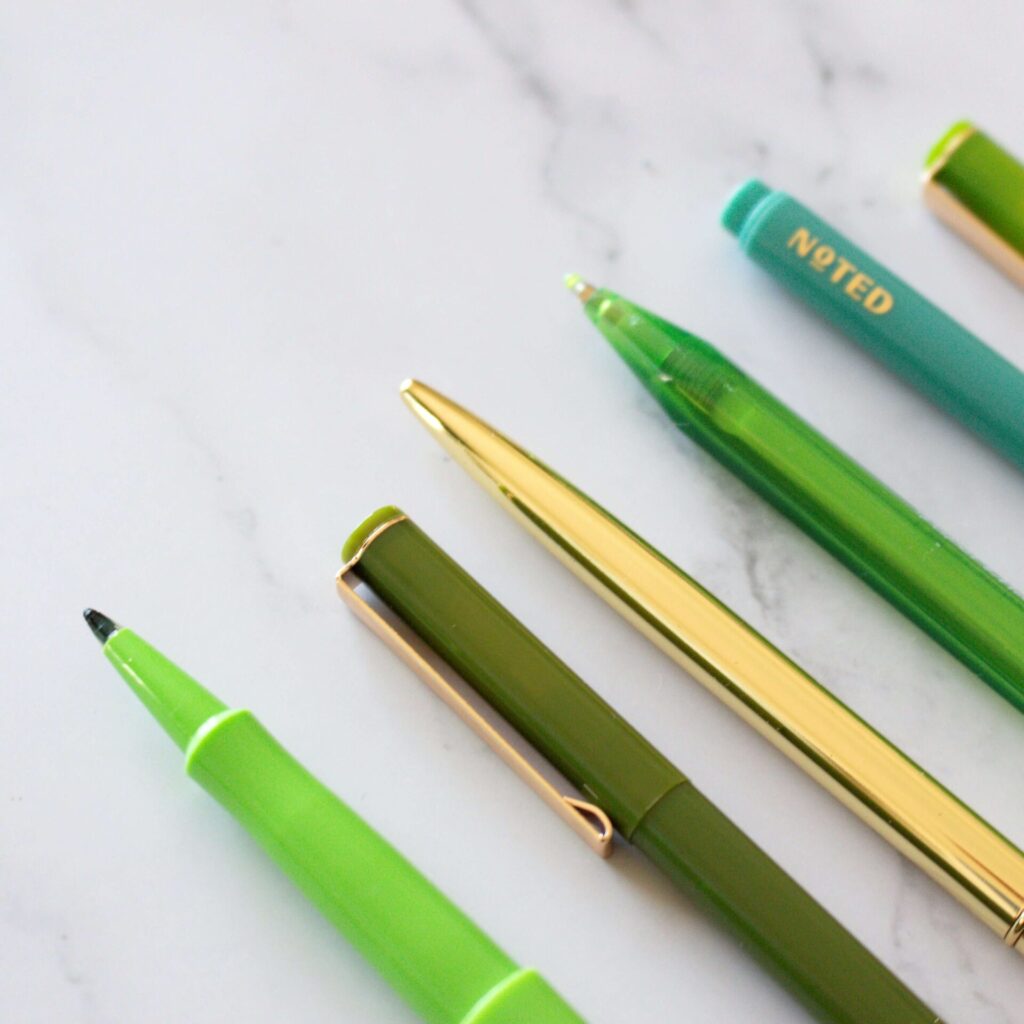 A collection of pens on a marble background makes for perfect tools for creative journaling.