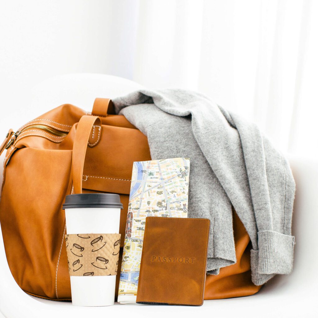 A collection of things you need to carry on a flight including a cup of coffee and your passport.