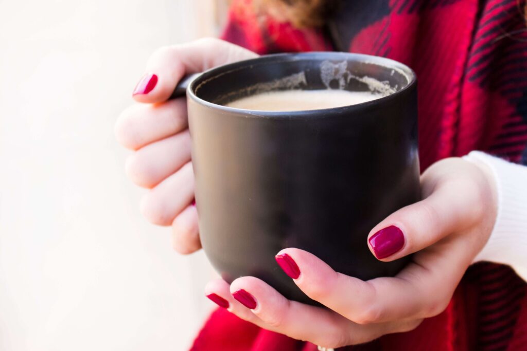 A warm cup of coffee in a woman's hands.