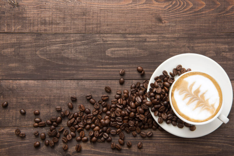 A cup of coffee on a wood background.