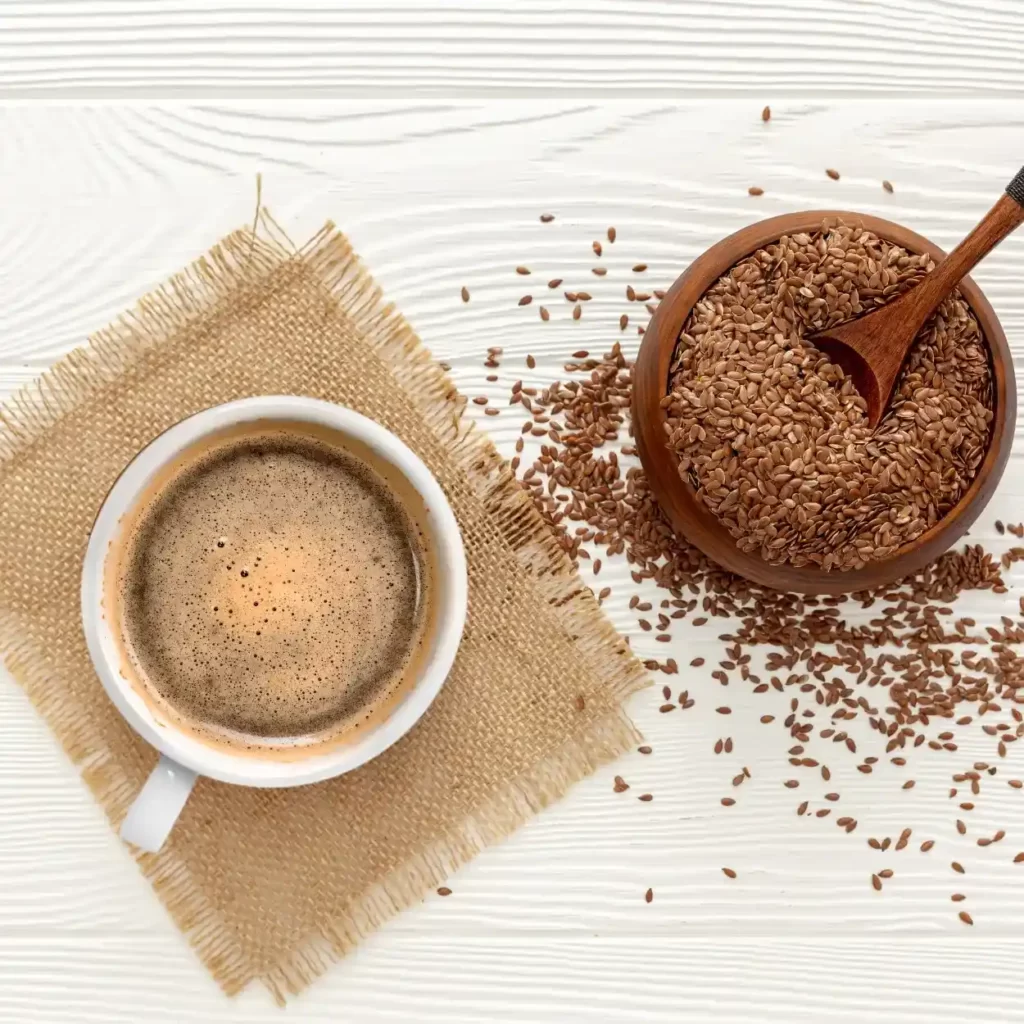A cup of coffee next to a bowl of flaxseed.