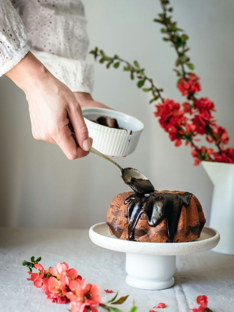 A coffee cake with a chocolate drizzle on top.