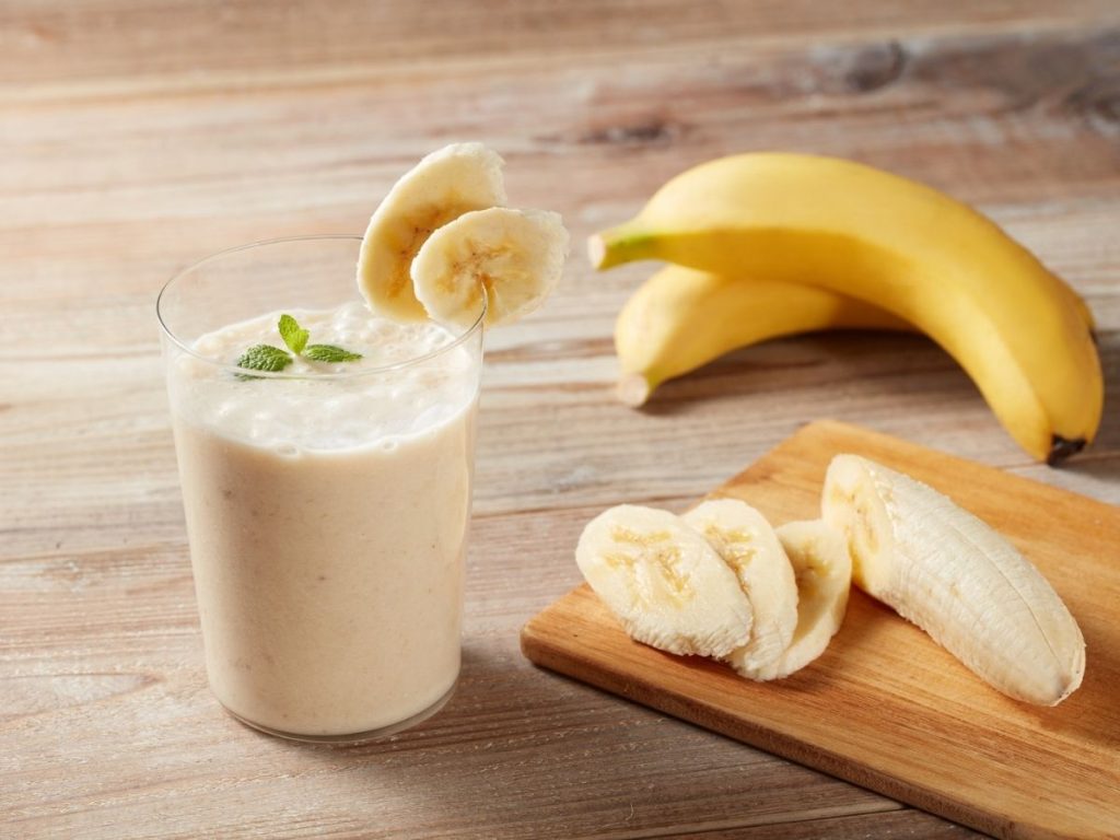 A picture of a banana latte next to cut bananas